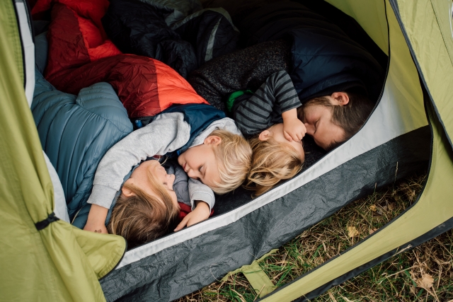 テント内でお昼寝している家族